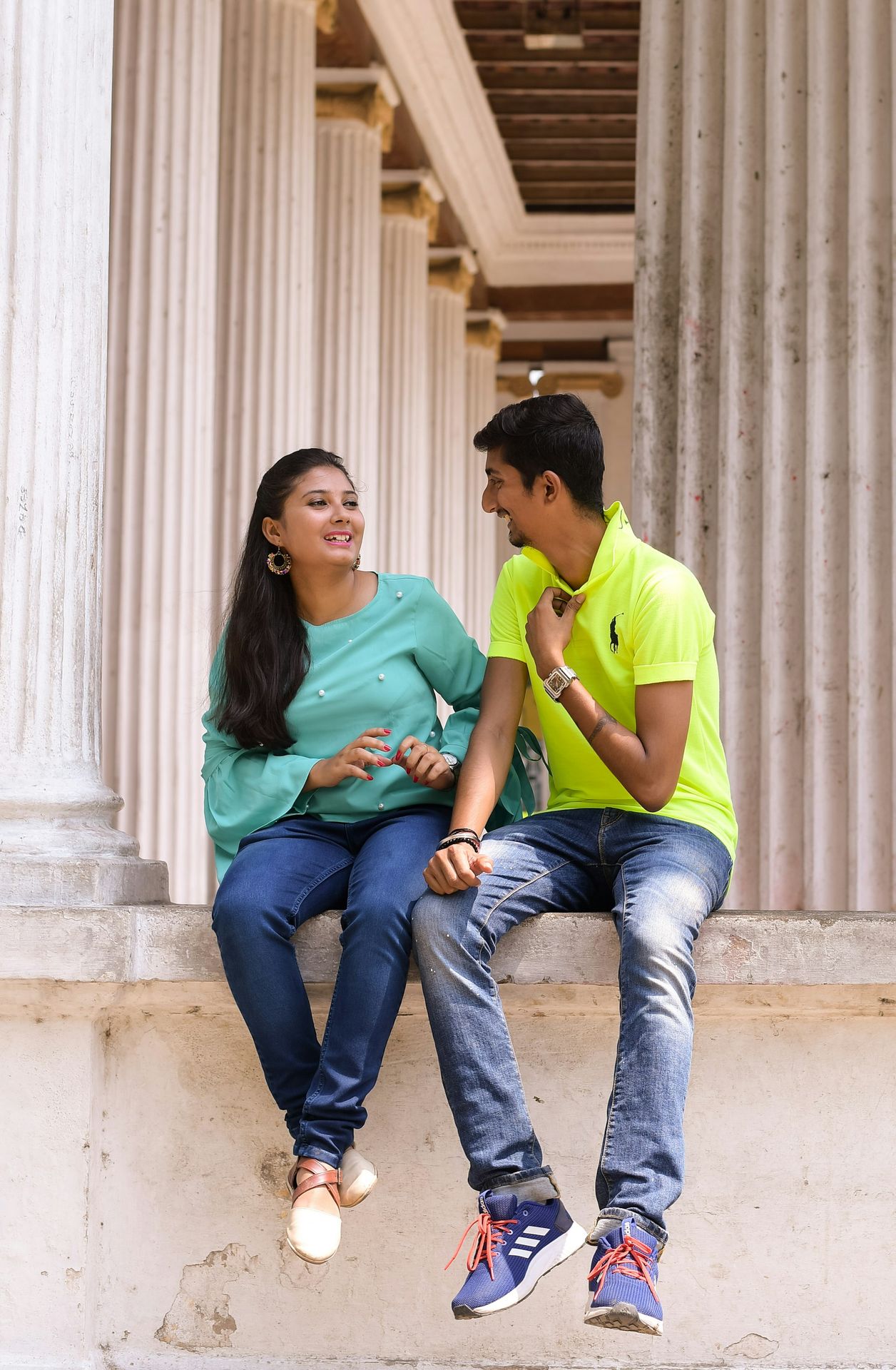 A man and a woman sitting on the steps of a building